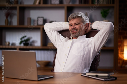 A successful man rests, reclases while sitting at the workplace. Businessman, manager in home comfortable office relaxed after successful work.