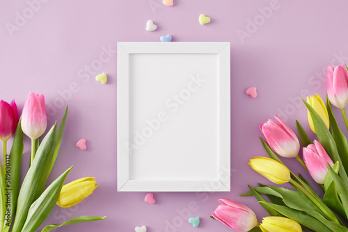 Happy Mother's Day concept. Creative layout made of vertical photo frame bouquets of flowers yellow pink tulips and small hearts baubles on isolated light violet background. Flat lay with blank space