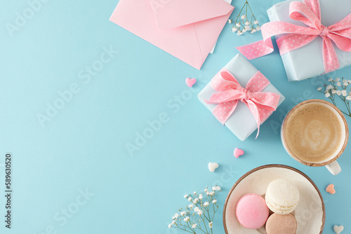 Top view photo of gift boxes cup of coffee plate with macaroons envelope small hearts and gypsophila flowers on isolated pastel blue background with empty space. Happy Mother's Day idea
