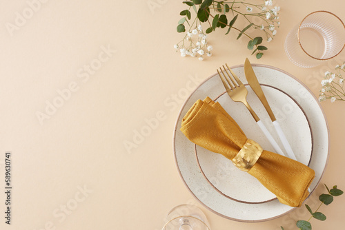 Table decor concept. Top view photo of circle plate cutlery knife fork napkin with ring empty glasses eucalyptus leaves and gypsophila flowers on pastel beige background with empty space