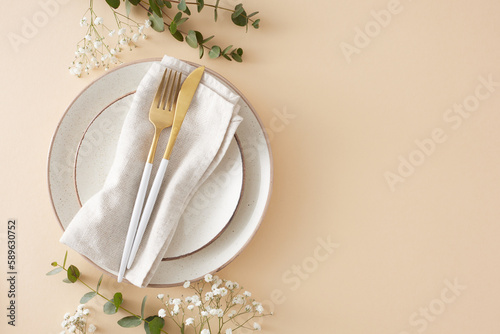 Table decoration concept. Top view photo of plate cutlery knife fork fabric napkin eucalyptus leaves and gypsophila flowers on pastel beige background with empty space