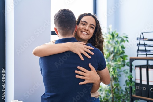 Young hispanic couple business workers hugging each other standing at office © Krakenimages.com