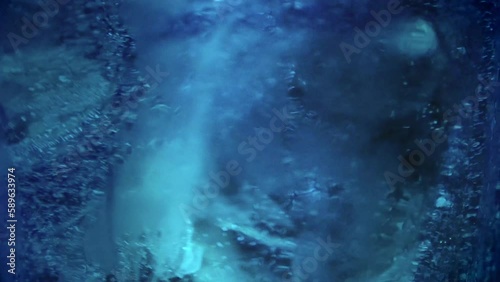 Close-up of ice and blue soda in a glass