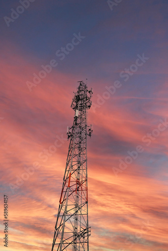 Telecommunication tower Antenna at sunset sky. vertical 