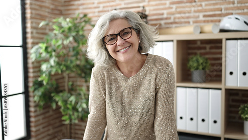 Obraz na plátne Middle age woman with grey hair business worker smiling confident at office
