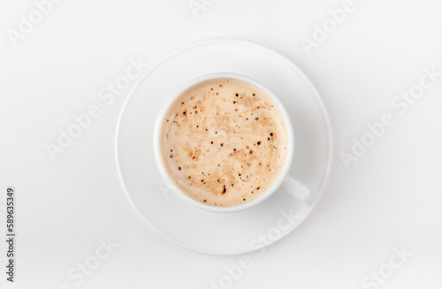 A white cup of coffee on a white background. Morning coffee with coffee foam. Top view.