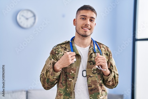 Young hispanic man army soldier doctor holding stethoscope at home