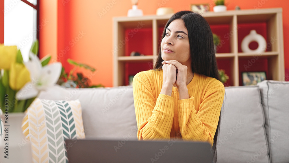 Young beautiful hispanic woman using laptop with doubt expression at home Young beautiful hispanic woman using laptop with doubt expression at home