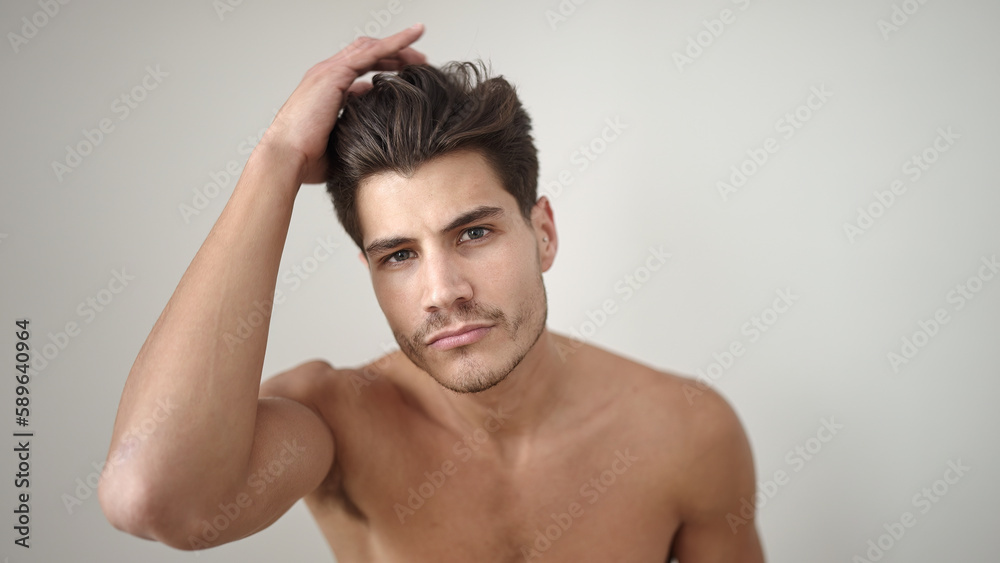 Young hispanic man combing hair with hand over isolated white background