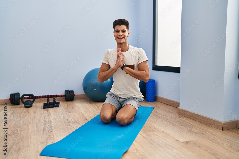 Young hispanic man smiling confident training yoga at sport center Young hispanic man smiling confident training yoga at sport center