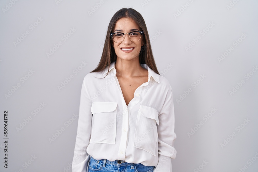 Young brunette woman wearing glasses with a happy and cool smile on face. lucky person. Young brunette woman wearing glasses with a happy and cool smile on face. lucky person.