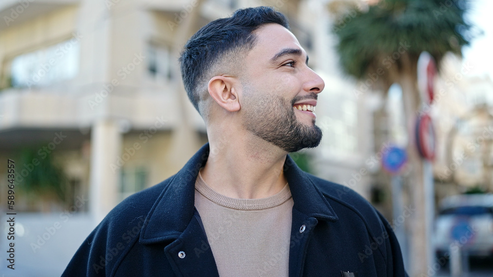 Young arab man smiling confident looking to the side at street