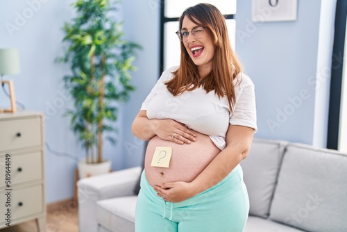 Pregnant woman expecting a baby wondering sex winking looking at the camera with sexy expression, cheerful and happy face.