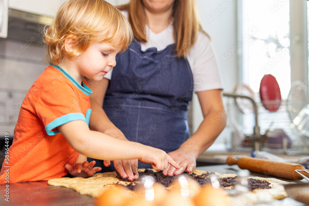 Mother and son boy making cookies and having fun in the kitchen