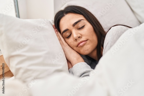 Young hispanic woman sleeping on bed at bedroom