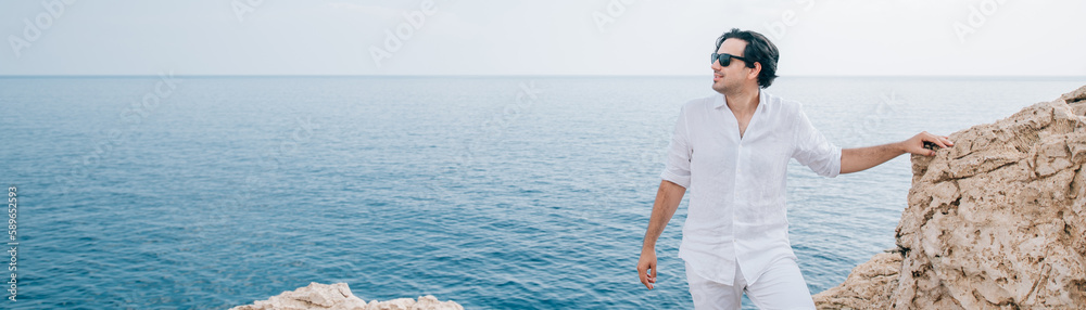 A man on the rocks overlooking the sea A man on the rocks overlooking the sea