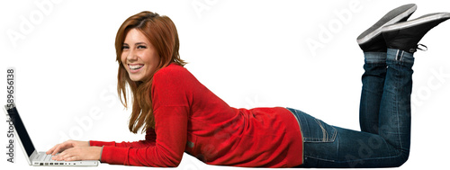 Portrait of beautiful girl using laptop and laughing while laying on a white background