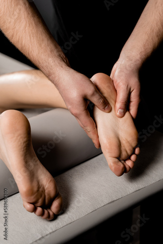 Professional masseur making foot and legs massage with massage oil. Relaxation. Massage of legs and foot in spa.