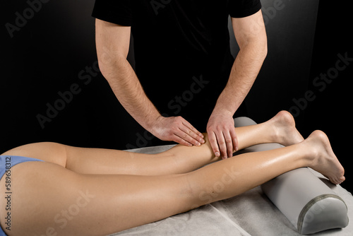 Foot and legs massage in spa. Masseur making foot and legs massage with massage oil. Relaxation.
