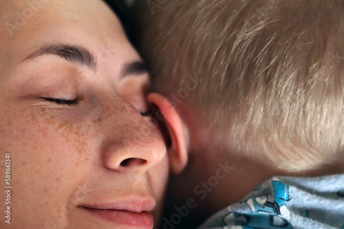 Closeup portrait of smiling mother which hugging her child. Family tenderness concept