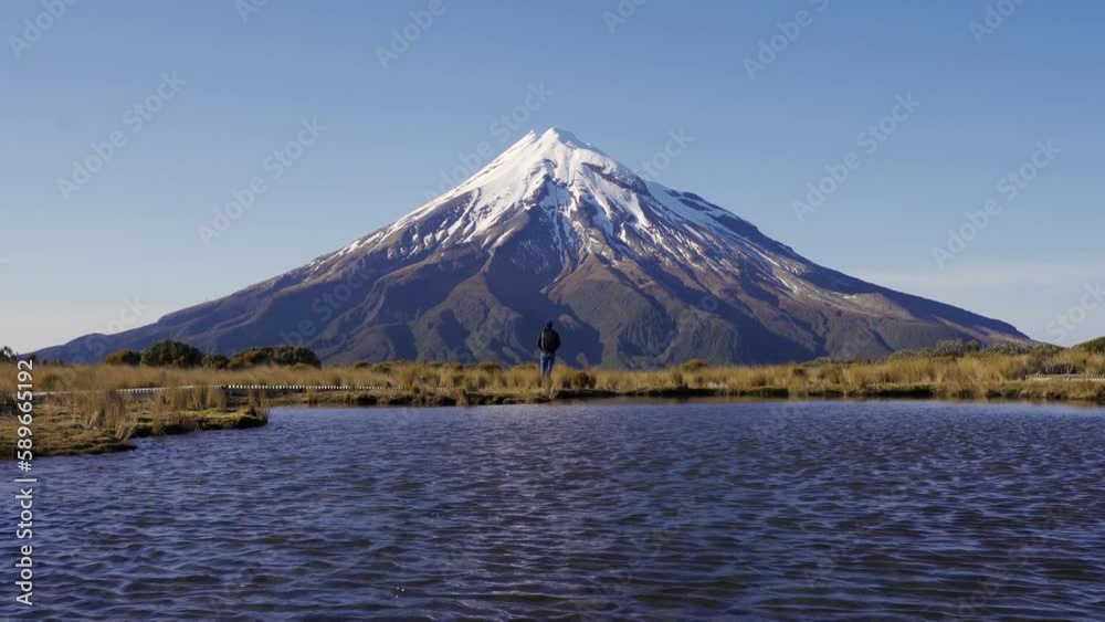 Man opening his arms at Mount Taranaki, Egmont National Park, New Zealand Man opening his arms at Mount Taranaki, Egmont National Park, New Zealand
