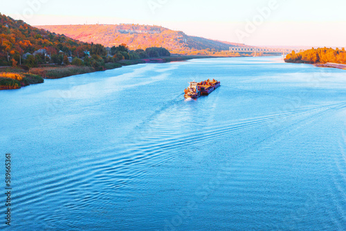 Nautical vessel at flowing river . Blue river water scenery 