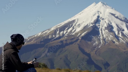 Young man pouring water on argentinian drink called mate in Mount Taranaki, New Zealand photo