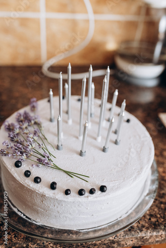 birthday cake with lavender and blueberries. silver candles on the cake
