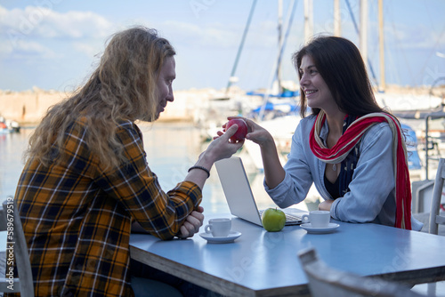 Young couple communicating at the table in the open cafe photo