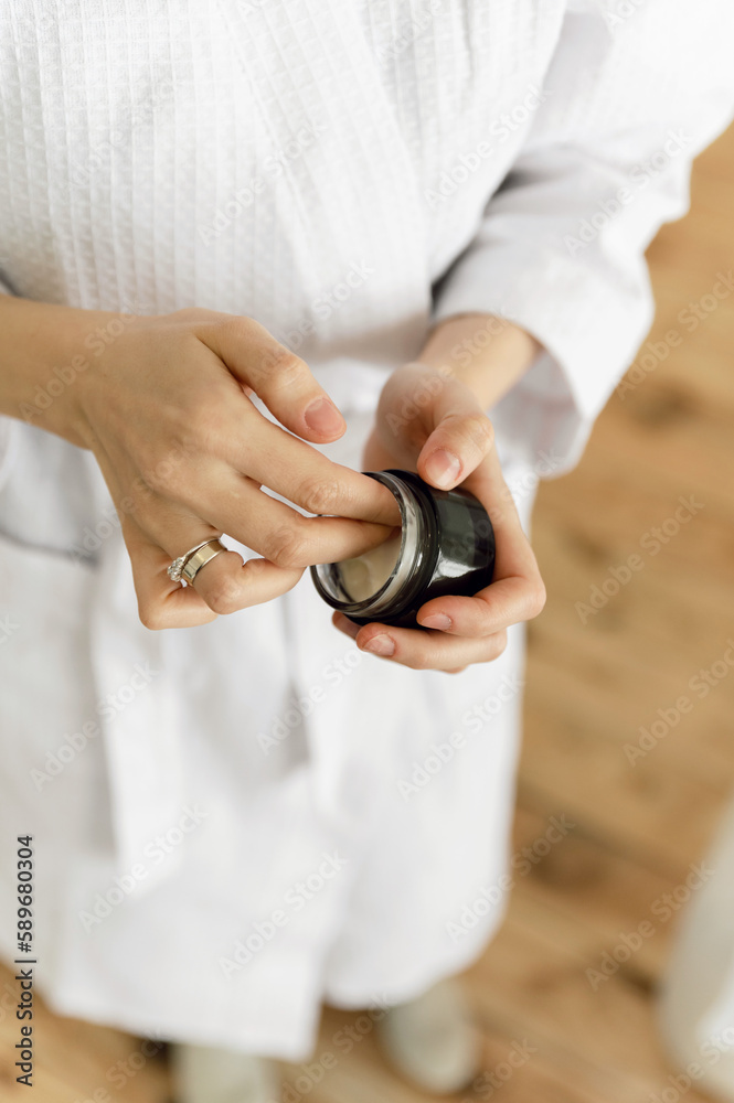 close-up of beautiful female hands holding body cream. cream is applied to the hands. body care. beauty cosmetics for women.