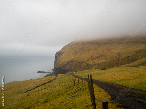 Grass fields by the coastline of Vágar island photo