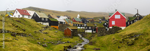 The brook passing by Mykines hamlet tuf roofed houses photo
