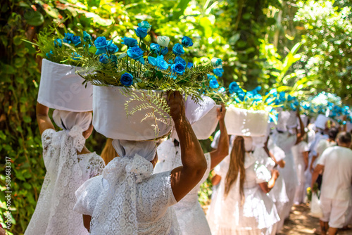 Praia de Trancoso, Bahia, Brasil. 2 de fevereiro de 2023. Mulheres carregando cestos de flores em Festa popular para celebrar o Dia de Iemanjá, o evento atrai pessoas de religiões afro-brasileiras photo