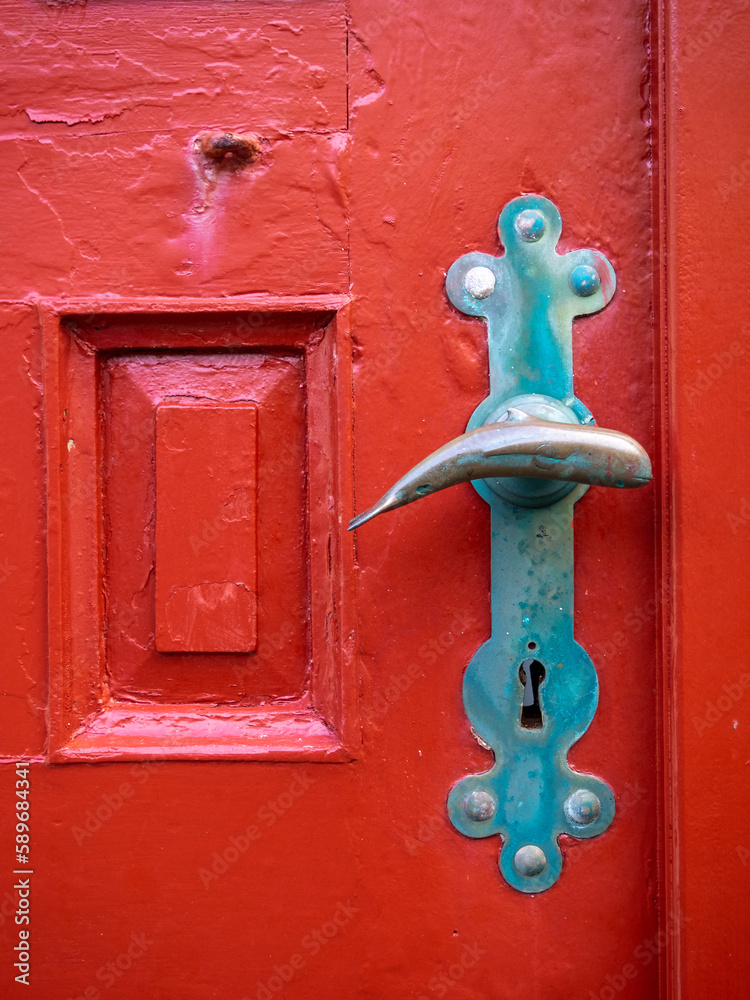 Whale shaped doorknob on the red door of Húsar church