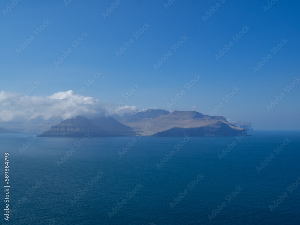 Eysturoy island and Gjogv hamlet in the horizon, seen from Kalsoy Kallur lighthouse hiking path