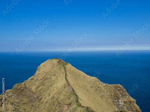 Two small tourists at the end of Kallur lighthouse hiking path in north Kalsoy island photo