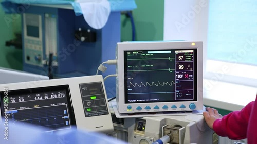 Equipment with screens switched on during operation. Modern medical apparatuses working in surgery room. photo