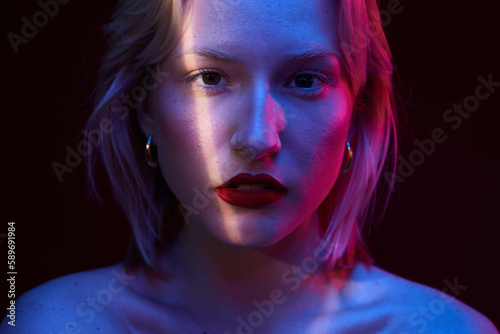 Beauty portrait of a woman with natural skin posing isolated on magenta background with photo gels. Viva magenta, color of the year.