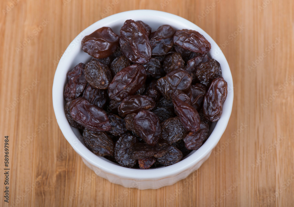 raisins in a bowl wooden background raisins in a bowl wooden background