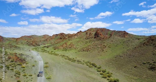 cars drive along a mountain road to a gorge in the mountains of Mongolia