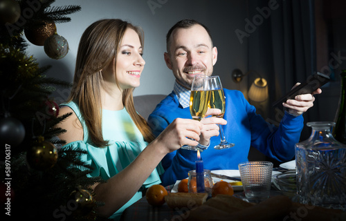 Christmas portrait of couple celebrating holiday and watching tv