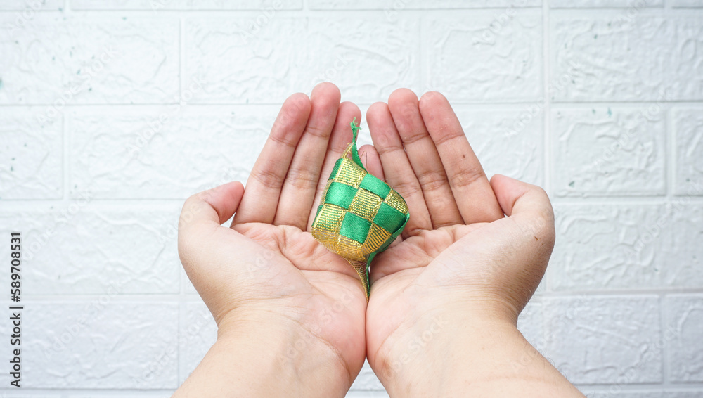 Hand Held Muslim Ketupat (Rice Dumpling). Translation: Eid Mubarak - Blessed Feast Hand Held Muslim Ketupat (Rice Dumpling). Translation: Eid Mubarak - Blessed Feast