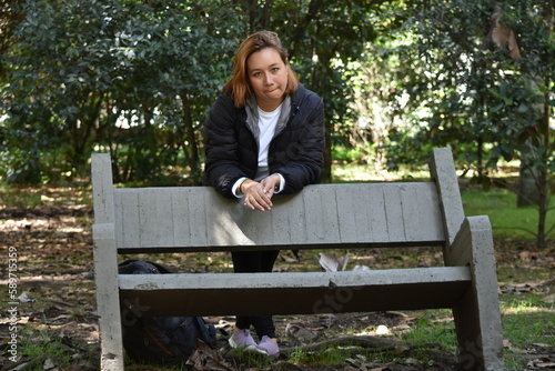 Model in a park behind a chair in the Botanical Garden of Bogota Colombia
