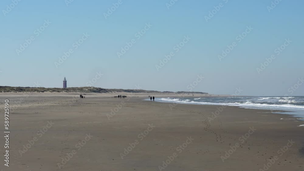 People Strolling At The Peaceful Beach Ouddorp With Westhoofd Lighthouse At The Background In The Netherlands. Wide Shot
People Strolling At The Peaceful Beach Ouddorp With Westhoofd Lighthouse At The Background In The Netherlands. Wide Shot