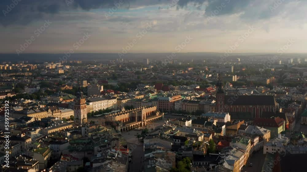 Panorama of Main Square (Saint Mary's Basilica, Sukiennice - Town Hall, Town Hall Tower) in Krakow, Poland during magic stormy weather with soft morning light. Panorama of Main Square (Saint Mary's Basilica, Sukiennice - Town Hall, Town Hall Tower) in Krakow, Poland during magic stormy weather with soft morning light.