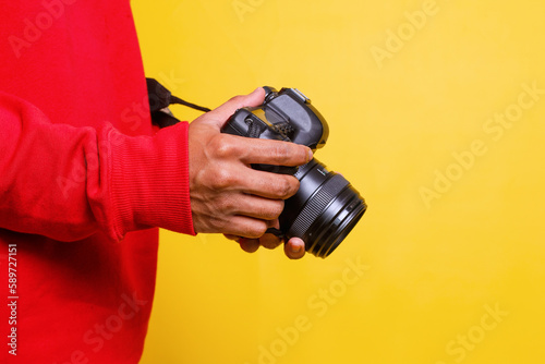 Принти на полотні Side view man photographer in red shirt makes photos isolated on yellow background