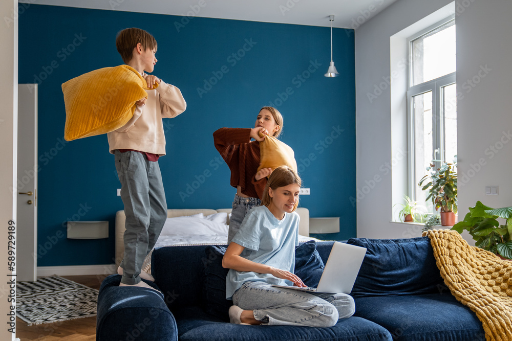 Work-family balance. Mother juggling working from home with looking ...