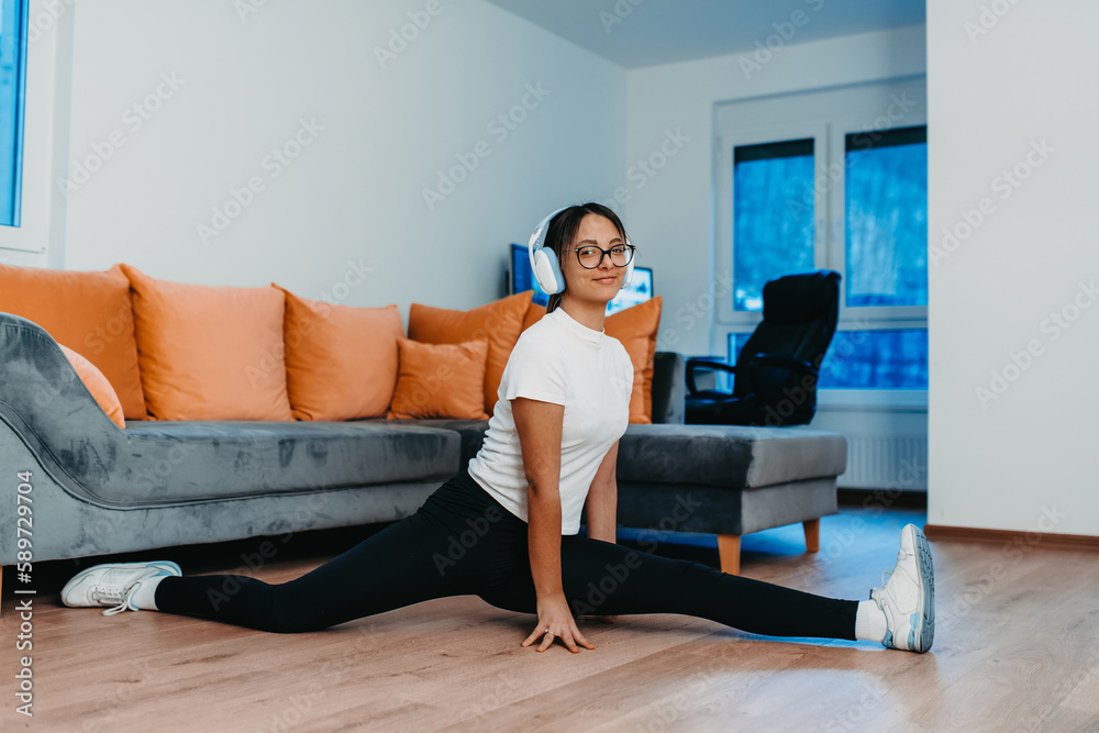 A woman stretching in her apartment during early morning after training , reflecting her dedication to a healthy lifestyle. This moment highlights the importance of regular exercise and self-care