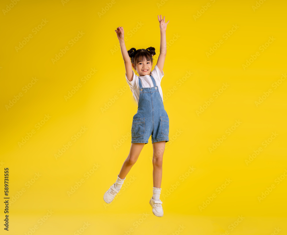 image full body of asian little girl posing on a yellow background image full body of asian little girl posing on a yellow background