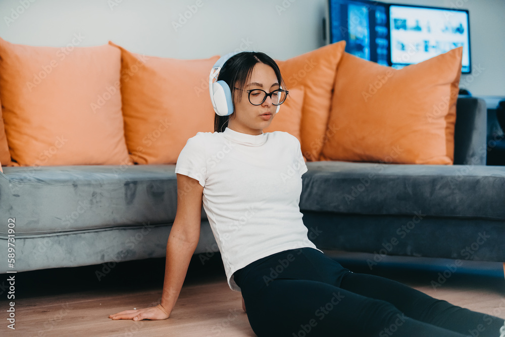 Obraz premium A woman stretching in her apartment during early morning after training , reflecting her dedication to a healthy lifestyle. This moment highlights the importance of regular exercise and self-care